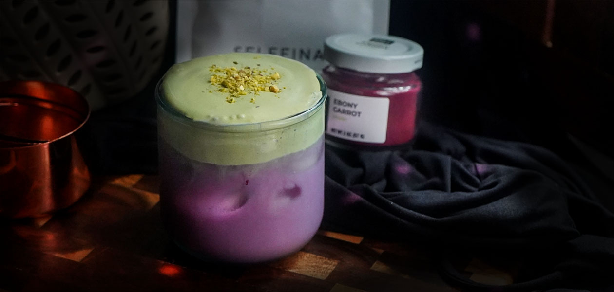 Spooky Matcha Foam Latte: violet ebony carrot milk under a pale green matcha foam with pistachios