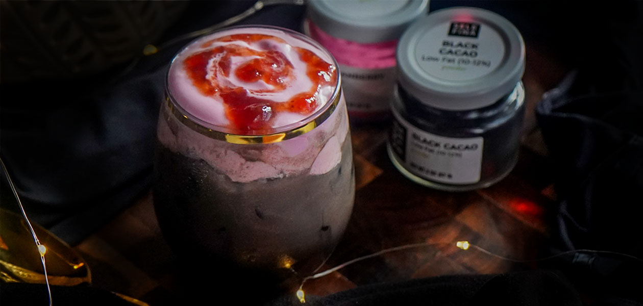 Dracula Foam Latte: dark black cacao latte under pink cranberry foam and a red berry swirl