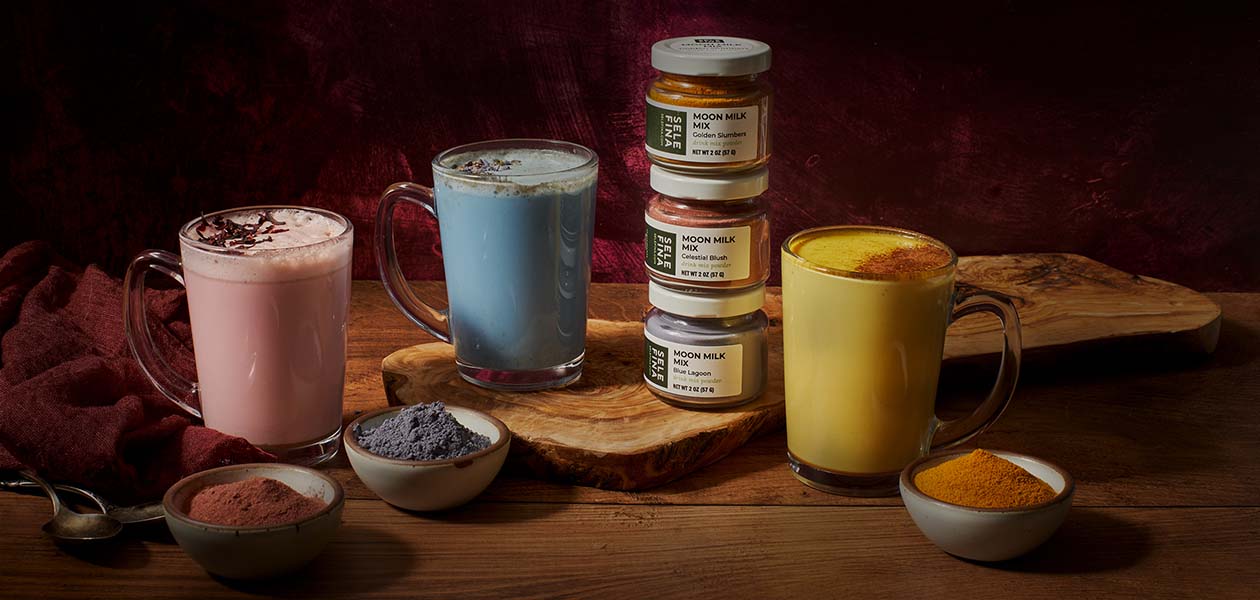 Pink, blue, and golden moon milks with a stack of Golden Slumbers, Celestial Blush, and Blue Lagoon jars