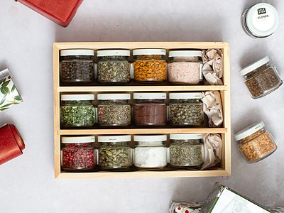 Twelve Selefina pinch jars standing in a wooden spice rack